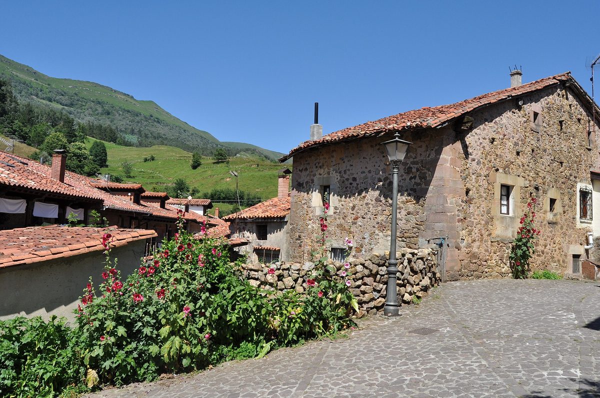 Una casa de piedra junto a una calle empedrada de Carmona, con el monte detrás