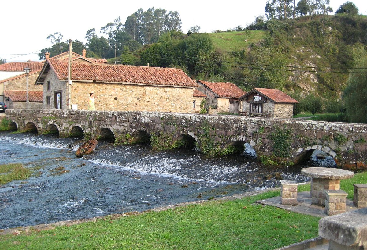 El puente de piedra de muchos arcos sobre el río, en Ruente